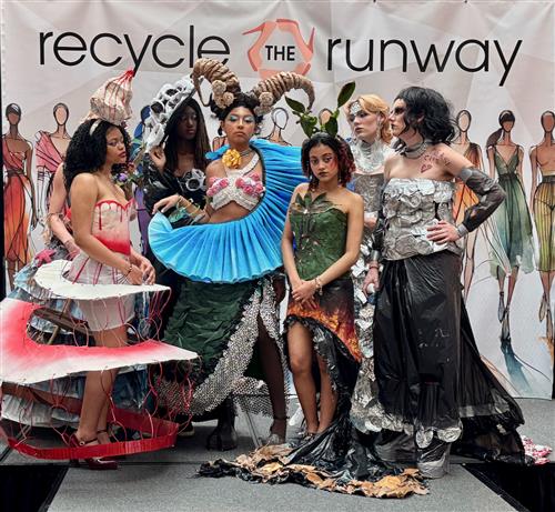  Models wearing dresses made of recycled materials pose for the camera